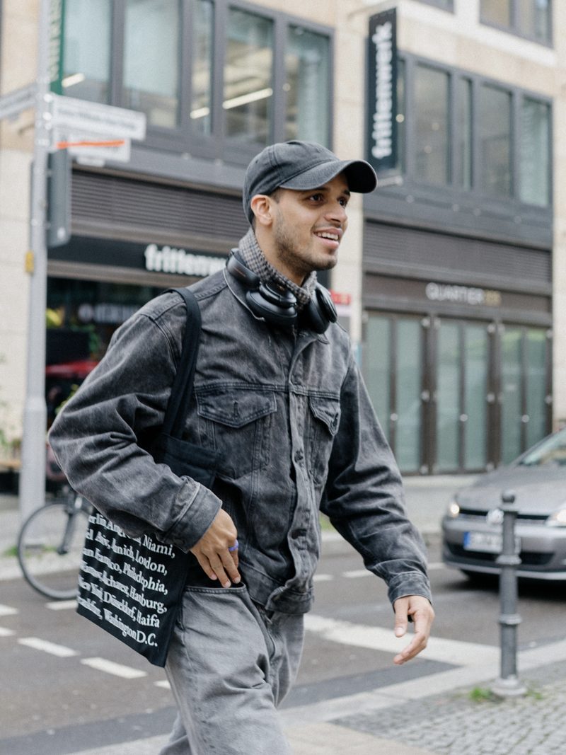 Manoj walking down a street in Berlin, smiling